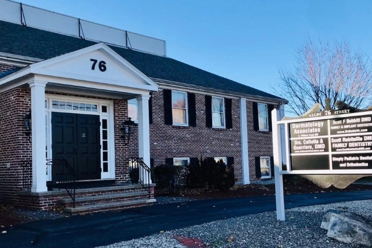 Brick residential home with white colonial-style entrance and black shutters at address 76.
