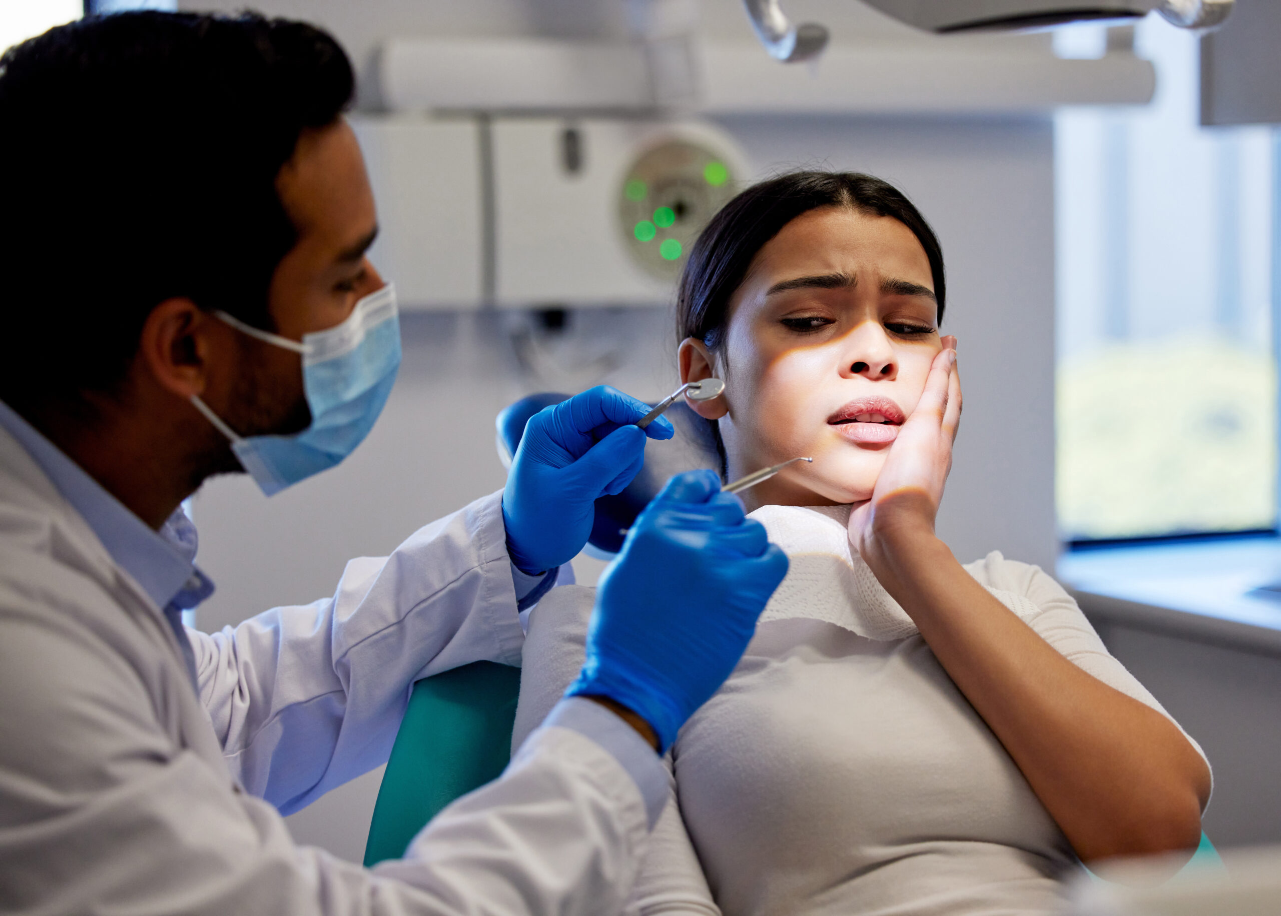 Patient experiencing dental emergency pain being examined by an emergency dentist at Nashua Smile Makers.