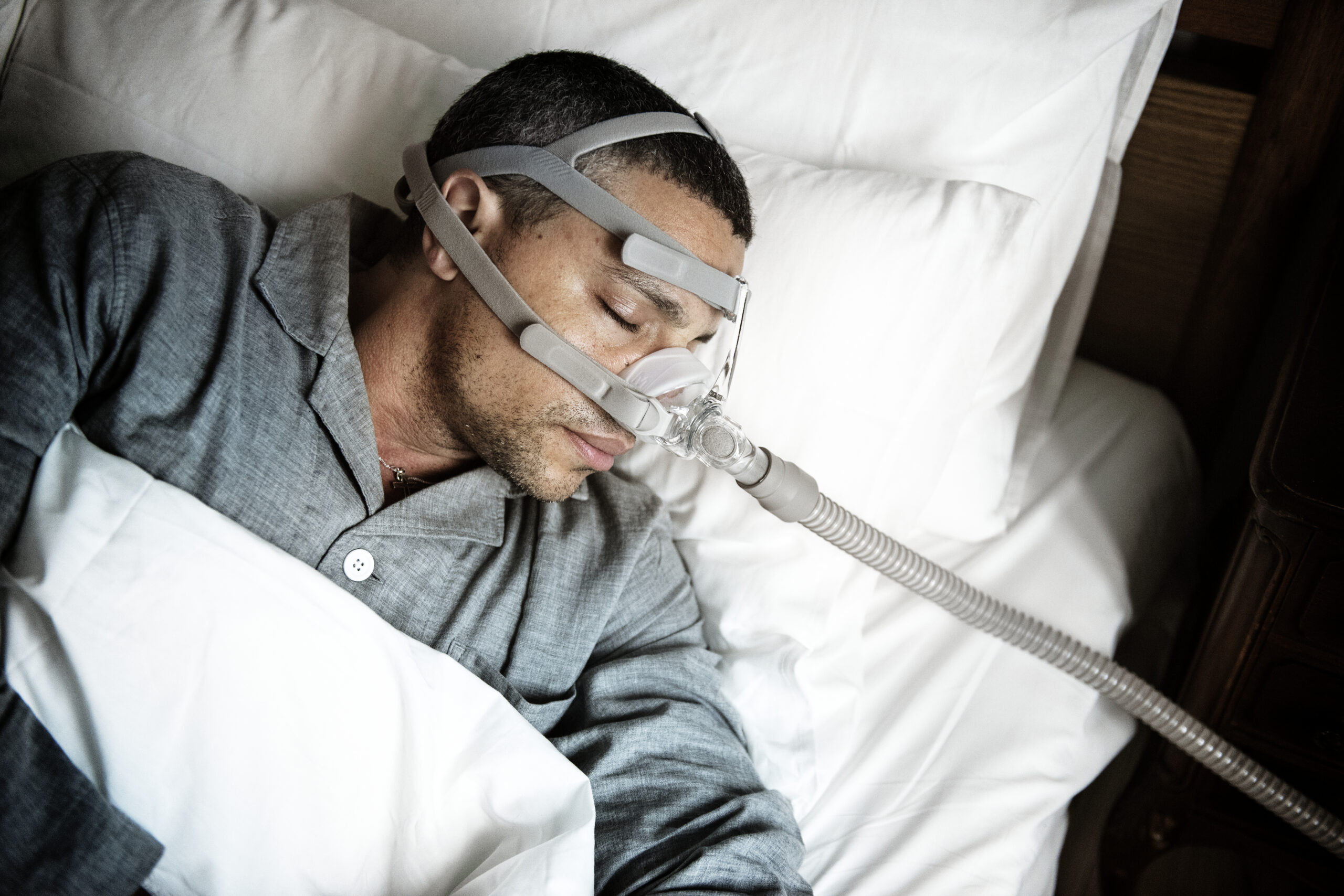 Patient sleeping with a CPAP mask while exploring sleep apnea treatment in Nashua at Nashua Smile Makers